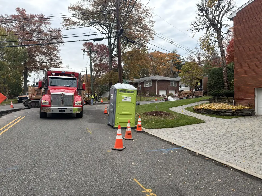 Portable toilet rental on a suburban street for road work in NJ.